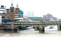 Comings and goings at Cannon Street in July 2005. View east along the Thames past the twin 120 ft red brick towers and walls that once supported the magnificent trainshed roof. The remains of the roof were removed in the 1950s following substantial bomb damage sustained during World War II.<br><br>[John Furnevel 23/07/2005]