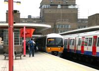 One of the Chiltern 165 DMUs arrives at Harrow-on-the-Hill on 23 July 2005. Alongside is a Metropolitan line train for Baker Street. The 165 is forming a Saturday morning service from Aylesbury to Marylebone and will run non-stop from here into the London terminus in 17 minutes.<br><br>[John Furnevel 23/07/2005]