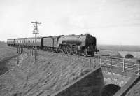 A1 Pacific no 60147 <I>North Eastern</I> approaching Innerwick in April 1964 with the 3.48pm (SO) Edinburgh - Berwick stopping train. The old A1 road can be seen crossing Dryburn Bridge beyond the train and Barns Ness lighthouse stands in the background. <br><br>[Robin Barbour Collection (Courtesy Bruce McCartney) /04/1964]