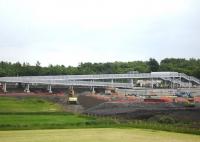 Mega footbridge structure at the new Blackridge Station site viewed from the A89 on 23 June, with the rail trolley of the tracklaying train having run to the rear of the unit in the station area to collect further supplies of sleepers. <br><br>[David Pesterfield 23/06/2010]