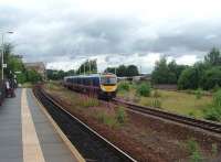 Although many tracks have been lifted at Mirfield three lines survive and they all serve station platforms. TPE 185141 hurries away from the camera non stop towards Heaton Lodge Junction where it will bear left for Huddersfield and Manchester A stopping service formed by 155344 can just be seen standing at the island platform with an eastbound service. This view was taken from the replacement Platform3  , a location where westbound stopping trains are often held while a TPE overtakes.<br><br>[Mark Bartlett 20/07/2010]