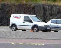 It looks like our national infrastructure operator is branching out <br>
into retail ironmongery, at least according to this van seen at <br>
Inverkeithing station on 24 July. Behind it, the marks in the rock show why it took so long to widen the vehicle access to the station a few years ago to include a bus turning circle. The brambles turn out to have been surviving on a thin covering of soil on top of solid rock which had to be laboriously (and noisily) chipped away. Blasting would have been out of the question, I imagine...<br>
<br><br>[David Panton 24/07/2010]