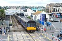 The 13.23 Exmouth - Paignton DMU (142029) arrives at Paignton on 24 July 2010 via Torbay Road level crossing.<br><br>[Peter Todd 24/07/2010]