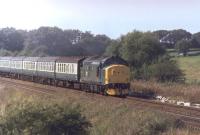 It's Summer Bank Holiday 1982 and a Saturdays only train from Blackpool North heads east at Kirkham behind now preserved EE Type 3 no 37215. [See image 29976].<br><br>[Mark Bartlett 28/08/1982]