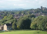 The 1640 Glasgow to Euston Pendolino leaves Lancaster on time at 1844 heading south. Lancaster's Priory Church is on the hill overlooking the station and the Lake District mountains can be seen behind. The low fence in the foreground is on the towpath of the Lancaster Canal.<br><br>[Mark Bartlett 27/07/2010]