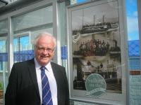 In addition to the Alastair Alexander photomontage, also now on permanent display along the covered walkway to the present pier at Gourock are nine posters showing collages of ships sailing down the Clyde. These were put together from illustrations supplied by Ian McCrorie, seen here at Gourock alongside one of the posters on 5 September. [See adjacent news item].<br><br>[John Yellowlees 05/09/2012]