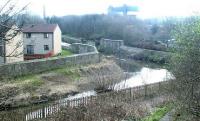 Remains of the bridge carrying the former NB line across the Water of Leith from Bonnington East to Bonnington South Junctions in March 2003 [see image 5635]. The line continued on to Powderhall station on the site of which the waste disposal depot can be seen in the distance.<br><br>[John Furnevel 10/03/2003]