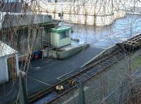 The loading apron at Powderhall depot in January 2003 with compacted refuse containers stacked in the background. The container flats are  positioned using the cable running from the winchroom on the left and connected to the train via the yellow loop box between the rails.<br><br>[John Furnevel 12/01/2003]