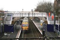 Looking west over Shettleston station from the Hallhill Road overbridge on 20th December 2011. The final touches are currently being applied to the newly erected replacement footbridge as westbound 334 022 passes under the rusting original structure beyond [see image 18009].<br><br>[Colin McDonald 20/12/2011]