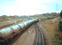 Type 2 crossing the ECML with a Millerhill bound freight at Portobello East Junction in October 1978. The deck of the bridge in the background, which formerly carried the Lothian Lines, has been removed by this time. Note the sizeable embankment on either side. On the left is part of the area once occupied by the extensive Portobello yards.<br><br>[John Furnevel 26/10/1978]