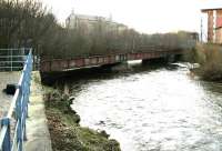 Looking west over the River Kelvin in February 2005 from the car park of Glasgow Museum of Transport off Bunhouse Road. The photograph shows the girder viaduct that once carried the Glasgow Central Railway across the River towards Partick Central station, whose former main entrance and booking office can be seen standing on Benalder Street in the right background.<br><br>[John Furnevel 19/02/2005]