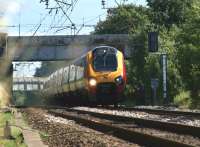 4 and 5 car Voyager sets head north at Coppull between Wigan and <br>
Preston on 16 July 2010. The photograph is taken looking through the fence where a public footpath crosses the line with the assistance of a footbridge. The WCML used to be 4 track here for a further two miles to the south to Standish Junction. It was reduced to two tracks up to Balshaw Lane Junction following electrification in the 1970s.<br><br>[John McIntyre 16/07/2010]