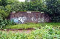 The surviving south abutment of the former Paisley & Barrhead Railway bridge over the Paisley Canal line, taken through a fence alongside the latter in August 2010.<br><br>[Colin Miller 02/08/2010]