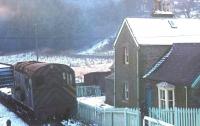 A track recovery train about to pass the station house and run over the level crossing at Newcastleton on its way north in late 1969. The former station house still stands [see image 17534]. <br><br>[Bruce McCartney //1969]