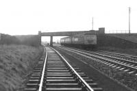 On a dull, damp April morning in 1969, a Glasgow-bound InterCity DMU runs under the Kilbarchan loop flyover south of Glengarnock station shortly after passing Brownhill Junction.<br><br>[Colin Miller /04/1969]