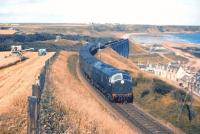 An eastbound mixed freight and passenger train approaching Cullen on the former Great North of Scotland Moray Coast line on 29th August 1961 behind an NBL Type 2 locomotive. The town of Portnockie stands in the background.<br><br>[Frank Spaven Collection (Courtesy David Spaven) 29/08/1961]