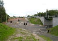 The new road layout at Uphall on 27 July 2010 lookng east towards Edinburgh with the M8 motorway on the left and Uphall station on the right. The photograph shows the new 'crossroads' created between the road and rail bridges allowing for future vehicle access from the B8046 to the now cleared area earmarked for future development along the north side of the station. [See image 30301]<br><br>[John Furnevel 27/07/2010]