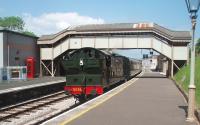 From country junction to engineering hub. Churston was, until 1963, the junction for the short branch to Brixham but the station is now the engineering centre for the company that owns the steam railway. The Brixham bay is now occupied by the workshop that can be seen at the end of the platform to the right of the train. An even larger workshop backs onto the opposite platform occupying the old goods yard. GWR 2-8-0T 5239 calls at Churston on a Paignton to Kingswear service in June 2010.<br><br>[Mark Bartlett 14/06/2010]