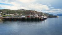 Kyle of Lochalsh station pier and the Admiralty pier viewed from the Kyle - Kyleakin ferry in 1991. 37408 and a tour train are in the station.<br><br>[Ewan Crawford //1991]
