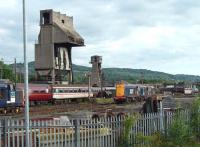 Four DRS Class 20s (20314/307/313/303) are presently stored at West Coast Railways at Carnforth, along with three DRS Class 37s. 37605 is seen here facing the 20s in the shadow of the famous Carnforth coaling tower, as seen from the Barrow platform of Carnforth station. 37612 and 37261 were also present coupled to 37605 just out of picture.  <br><br>[Mark Bartlett 27/08/2010]