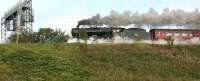 The last run for this summer of <I>The Welsh Mountaineer</I> on 25 <br>
August 2010 sees ex-LMS 8F 2-8-0 no 48151 <I>'Gauge O Guild'</I> charge southwards along the WCML from Preston with whisps of steam emanating from the cylinder draincocks. The train is about to cross Factory Lane, Penwortham. Summer must be over as this is the first dry and bright Wednesday morning that this train has seen!<br>
<br><br>[John McIntyre 25/08/2010]