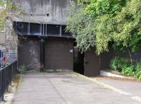 The former Glasgow Central Railway station at Kelvin Bridge is <br>
adjacent to the Subway station called Kelvinbridge (one word). Although the trackbed is filled in at this point the platforms survive and the edge of the northbound platform can be seen here on 1 September, looking north towards the next stop, Botanic Gardens. The daylight seen through that door lasts for only a few yards as the line went into a tunnel directly under and following Great Western Road. [See image 30544]<br>
<br><br>[David Panton 01/09/2010]