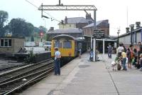 A quiet Saturday at St Botolphs station, Colchester, in August 1980. A DMU for Sudbury is about to depart while shoppers wait for the following electric service down the line to Clacton and Walton. Amidst the harmony there is, by current standards, a discordant note, and that is the small boy in a driver's hat about to climb into the empty cab. The youngster was being treated to an unofficial cab ride from Sudbury and back, and no doubt he had a memorable day. The signalman remarked that lots of strange things happened at weekends because there were no [expletive deleted] inspectors about.<br><br>[Mark Dufton 09/08/1980]