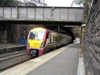 On 1 September 334 011 bursts out of Newton Street tunnel into <br>
Greenock West station, heading for Glasgow.  This is Scotland's longest tunnel at 1 mile 350 yards, or 1925 metres as the sign says.  The disused tunnel of the Greenock Princes Pier branch crosses above it. The work going on behind the train seems to be a very modest platform extension: unlike other affected locations not much work is needed here to accommodate 8-car Class 380s come December.<br>
<br><br>[David Panton 01/09/2010]