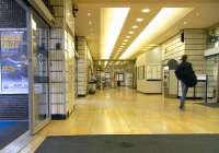 View from inside the Dundas Street entrance to Queen Street station <br>
on 11 September. The customer is heading for the main line platforms<br>
while the Low Level platforms are downstairs to the right at the end of the corridor ahead. Outside a poster advertises a musical called <br>
'Sunshine on Leith'. As a Leither I am surprised that such an everyday occurence is thought worthy of warbling about. [See image 4775]<br>
<br><br>[David Panton 11/09/2010]