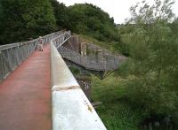 A replacement bridge over the Avon East of Chippenham on the Calne branch, which has recently been converted into a quality foot/cyclepath with a rolled stone surface, seen here in August 2010. Unusual features include the kink in the middle (no insult intended to the gent in shorts) and the lower level viewing platform on the right.<br><br>[Ken Strachan 30/08/2010]