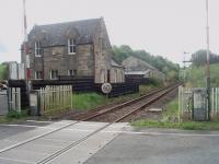 Kilkerran station, closed in 1965, still stands alongside the Stranraer line. This view from the level crossing looks south towards Girvan and shows the bracket semaphore protecting the crossing and the passing loop.<br><br>[Mark Bartlett 18/09/2010]