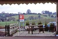 The station buffet/bar at Manningtree has a good reputation today, but in 1984 the ambience of its outdoor seating area left something to be desired. There weren't any customers prepared to relax in it on this day, but it was January 2nd and patio heaters were a long way in the future. At least there was a view of the countryside. Now it's a view of the car park.<br><br>[Mark Dufton 02/01/1984]