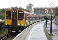 A wet 29 November 2006, with only a few weeks left for services on the North Woolwich branch. Silverlink dual-supply unit 313104 prepares to leave the terminus with a North London Line service to Richmond.<br><br>[Ian Dinmore 29/11/2006]