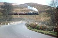 The Langholm branch train runs alongside the A7 about a mile south of the town heading for Carlisle in 1962. Nowadays the bridge over the Esk is controlled by traffic lights. For the scene forty-eight years later [see image 31011]. <br><br>[Bruce McCartney //1962]