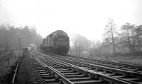 Border crossing at Kershopefoot in the 1960s. After running through Kershopefoot station, a class 37 is about to take a northbound freight over the Kershope Burn, with the lineside marker visible on the right.<br><br>[K A Gray //]