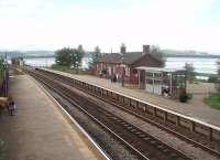 Arnside station is in a magnificent setting alongside the Kent estuary and yet close to the village centre. This view looks west, at high tide, with the famous viaduct just out of shot beyond the signalbox. The branch to Hincaster Junction on the WCML turned off by the signalbox and passed behind the station building to run alongside the estuary through Sandside. [See image 28623] <br><br>[Mark Bartlett 11/09/2010]