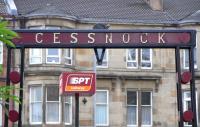 A slight nod to Mackintosh and the Glasgow Style is evident in this <br>
arch over the entrance to Cessnock subway, though the lettering is <br>
conventional.  Below the subway sign can be seen one of the hundreds of remaining brackets which once held the cables which in turn supported the tram wires.  In Glasgow little or no effort seems to have been made by the then Corporation in removing these, whereas in Edinburgh the effort was total as I've never seen any, only their 'shadows'.<br>
<br><br>[David Panton 16/10/2010]