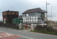 Steam age infrastructure survives today at Foxfield, including the water tower seen here in October 2010. The signalbox once controlled the junction for the Coniston branch but now just a section on the line from Barrow to Millom. The green building next to the crossing is the Lamp oil Store for the semaphore signals.  The station survives as a request halt on the edge of the Duddon estuary. <br><br>[Mark Bartlett 17/10/2010]