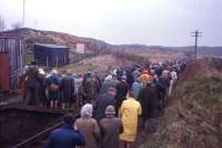 This looks like Scotland's rail equivalent of the Kinder Scout 'mass trespass', but in fact is almost certainly a 1973-74 official visit (via Duirinish station and the railway track) to the proposed oil platform construction yard at nearby Drumbeg by the Public Inquiry team, witnesses, objectors and supporters. The scheme was thrown out, and an alternative, less controversial, site developed on the north side of Loch Carron at Kishorn, which generated valuable freight traffic for the Kyle line at the Strome Ferry railhead for some five years.<br><br>[Frank Spaven Collection (Courtesy David Spaven) //]