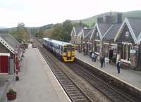 The original Midland Railway station buildings at Settle are seen to good effect as 158907 calls at on its way from Carlisle to Leeds. The real fire in the waiting room must be a welcome sight for passengers on chilly days like this.  View northwards towards Horton-in-Ribblesdale. <br><br>[Mark Bartlett 23/10/2010]