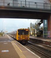 A morning rush hour Kirkby to Liverpool Central service, formed by 508104, calls at Kirkdale and stands under the modern bridge that carries a street level booking office and is connected to the platforms by lifts and 48 step staircases. Out of sight, in a tunnel directly underneath the station, is the still well used freight line to Seaforth Container Terminal on the River Mersey.<br><br>[Mark Bartlett 21/10/2010]