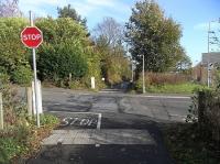 The site of Prestonhall Level Crossing on the Auchmuty Paper Mill branch in Glenrothes photographed from the trackbed looking east on 27 October.  Notice the rail still embedded in the road.  The view is taken from behind the site of the decrepit gate pictured a few years ago at image 27920.  This road here is in something of a backwater but it was once the main road north through Fife. <br><br>[David Panton 27/10/2010]