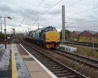 As the Class 37s celebrate fifty year's of main line service, two slightly younger members hustle a pair of flasks north through Bank Quay station. Still in front line service with DRS, second loco 37607 is approaching its birthplace, Vulcan Foundry, from where it emerged in January 1963 as D6803. Leading loco 37602 left Robert Stephenson & Hawthorn's plant in Newcastle two months earlier as D6782. <br><br>[Mark Bartlett 04/11/2010]