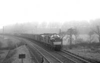 View north from Kershopefoot signal box on a grey day in the 1960s as a lengthy up Waverley route freight crosses the border on the approach to the station. The border signs can just be made out on the left of the photograph standing on each side of the Kershope Burn. The date of the photograph is 3 January 1969 and the locomotive no D6846.<br><br>[K A Gray 03/01/1969]