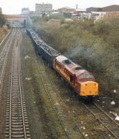 37716 reverses loaded scrap wagons out of the European Metals Recycling siding at Laisterdyke, Bradford, on 1 April 1998.  The train will use the crossover by the bridge to regain the main line and run down to Bradford Interchange, where it will run round before heading west via the Calder Valley to reach its ultimate destination at Liverpool's Alexandra Dock. The unused track to left of the loco, which was formerly a part of the east to south avoiding line that formed a triangle with the Halifax line, continues a short distance to a run round loop and head-shunt [See image 30126]. As of 2016 the loco is still at work, now with DRS. <br><br>[David Pesterfield 01/04/1998]