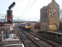 Early morning at Carnforth sees a Barrow to Manchester Airport service approaching the station. 185147 is just clattering over the points for the Settle Junction line and about to pass the original stone signal box, replaced long ago by the still operational Carnforth Station Junction box that is hidden by the train. The long footbridge was the original pedestrian route to Carnforth shed but has not been accessible for many years.<br><br>[Mark Bartlett 16/11/2010]