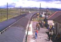 Rail-borne guests of BR from Inverness have just alighted from a southbound train at Dalwhinnie in 1976 to view the reinstatement of double track to Blair Athol. A northbound passenger service is in the Down loop, while an engineer's train waits in the refuge sidings.<br><br>[Frank Spaven Collection (Courtesy David Spaven) //1976]