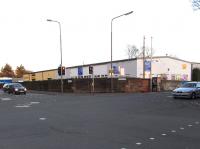 An overbridge on the Caledonian's meandering goods branch from Newhaven to Leith Docks once dominated the scene here, running diagonally over a crossroads. Now only a practised eye can spot that the wall on the corner of Bonnington Road and Pilrig Street is a cut-down abutment.Behind it the commercial premises occupy the trackbed which was quickly flattened after closure in 1968 or so, but the embankment still exists at the other side of Pilrig Park [see image 25918].<br><br>[David Panton 13/11/2010]