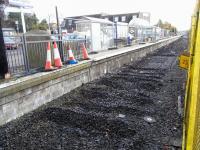 A few short weeks after the closure of the 1986 Bathgate station all track on its dedicated line has been removed and workmen are busy dismantling the station fittings. Nothing much has changed from the street point of view however and the double arrow sign is still there out there on the roadside. View out from the buffer stops into a low winter sun on 24 November 2010.<br><br>[David Panton 24/11/2010]