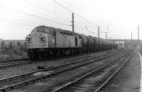 The old Liverpool and Manchester main line sees split headcode Class 40 40132 heading west and approaching Newton-le-Willows station with a train of oil tanks. The train is just passing Parkside Colliery, whose exchange sidings are in the foreground. The M6 Motorway overbridge can be seen in the background and Parkside's two modern winding towers were a prominent landmark to motorists for many years until they were demolished after its closure in 1993. <br><br>[Mark Bartlett 25/10/1980]